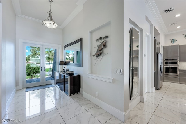 interior space featuring french doors, a towering ceiling, and crown molding