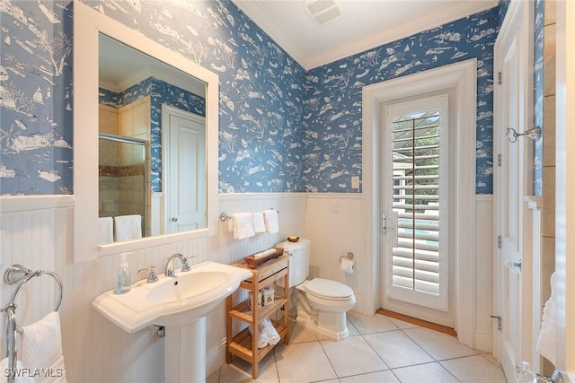 bathroom with tile patterned flooring, toilet, walk in shower, and crown molding