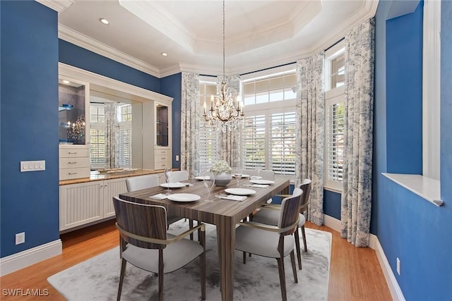 630 Mooring Line Dr, Naples, FL 34102 - dining space featuring a tray ceiling, a notable chandelier, light wood-type flooring, baseboards, and ornamental molding