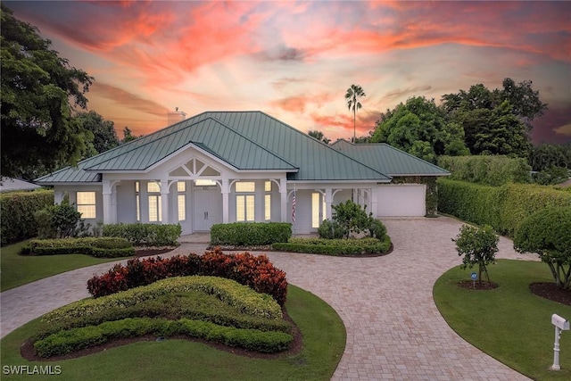 630 Mooring Line Dr, Naples, FL 34102 - view of front of home featuring a front yard, decorative driveway, a standing seam roof, and metal roof