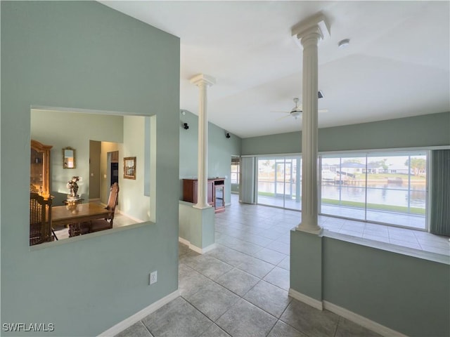 corridor featuring light tile patterned floors, decorative columns, and a healthy amount of sunlight