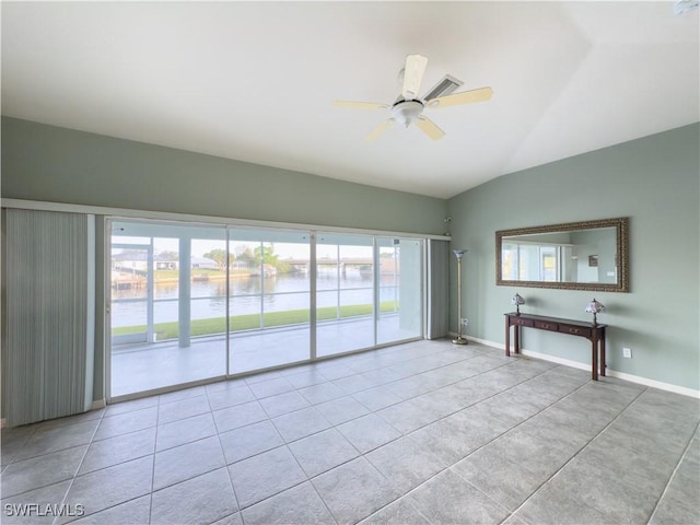 spare room featuring ceiling fan, a healthy amount of sunlight, a water view, and vaulted ceiling