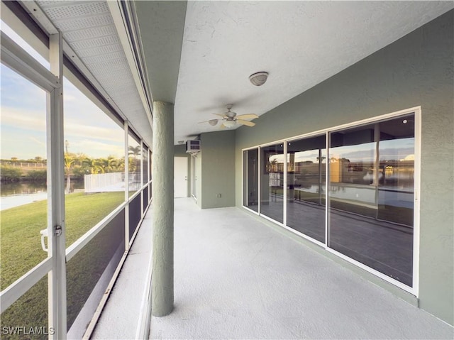 unfurnished sunroom with ceiling fan