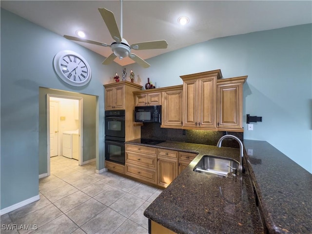 kitchen featuring decorative backsplash, dark stone counters, black appliances, sink, and washing machine and dryer