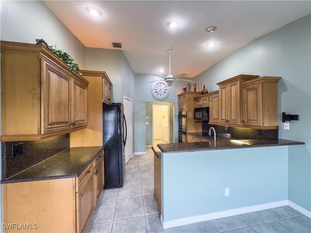 kitchen featuring kitchen peninsula, ceiling fan, black appliances, light tile patterned floors, and dark stone countertops