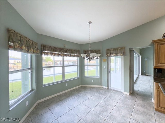 unfurnished dining area featuring a notable chandelier, light tile patterned flooring, and vaulted ceiling