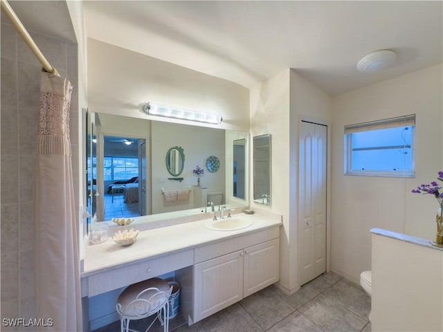 bathroom with tile patterned floors, vanity, a healthy amount of sunlight, and toilet