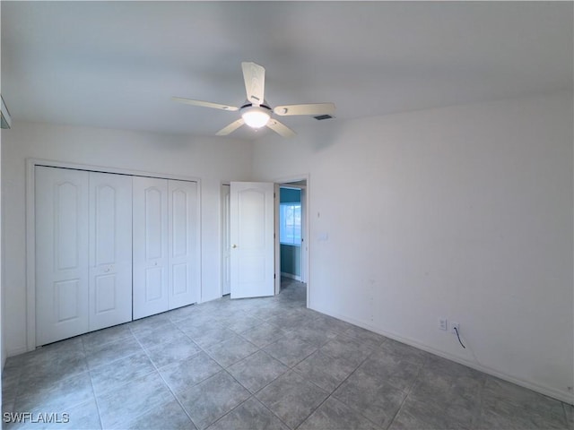 unfurnished bedroom featuring tile patterned flooring, ceiling fan, and a closet