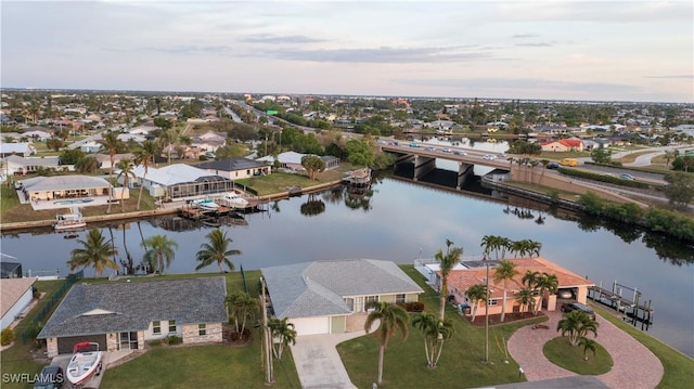 aerial view at dusk featuring a water view