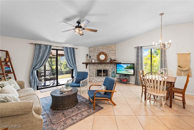 tiled living room with ceiling fan with notable chandelier, a stone fireplace, and lofted ceiling