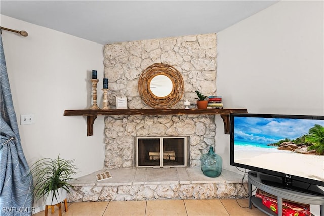 tiled living room with a stone fireplace