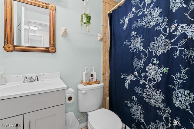 bathroom with vanity, curtained shower, and toilet