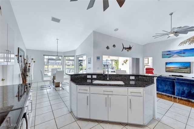 kitchen with white cabinetry, sink, a kitchen island with sink, light tile patterned floors, and ceiling fan