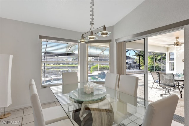 tiled dining area with vaulted ceiling and ceiling fan