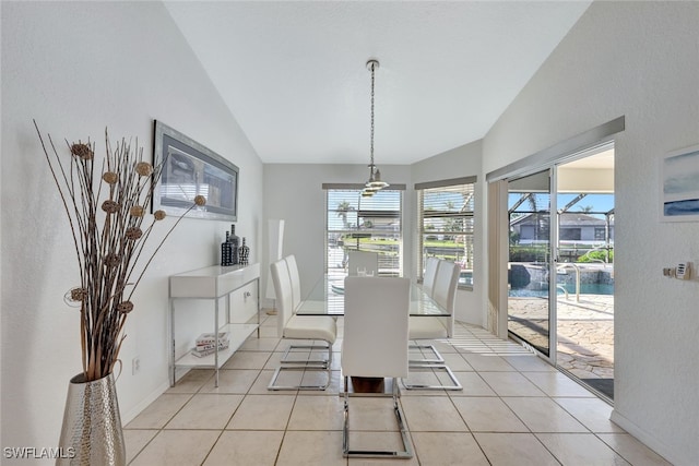 dining space featuring light tile patterned flooring and vaulted ceiling