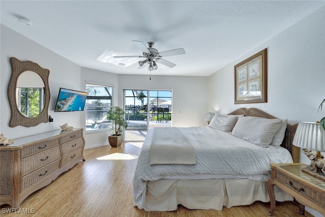 bedroom featuring access to exterior, light hardwood / wood-style floors, and ceiling fan