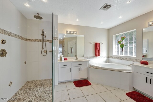 bathroom with vanity, separate shower and tub, tile patterned flooring, and a textured ceiling