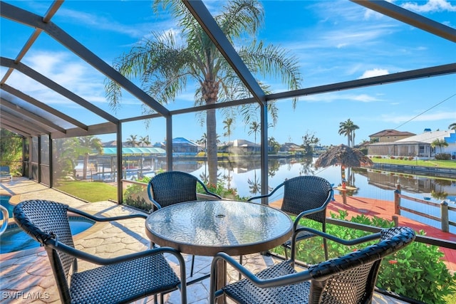 sunroom featuring a water view