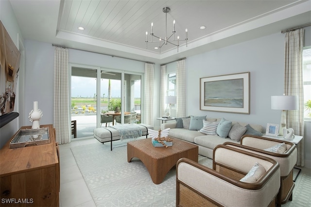 living room featuring recessed lighting, a raised ceiling, and a notable chandelier