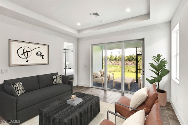 tiled living area with baseboards, visible vents, a raised ceiling, and recessed lighting