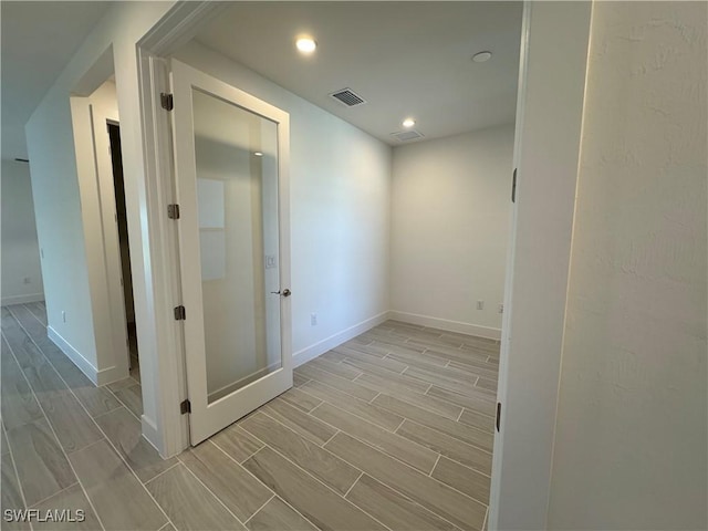 unfurnished room featuring wood tiled floor, visible vents, baseboards, and recessed lighting