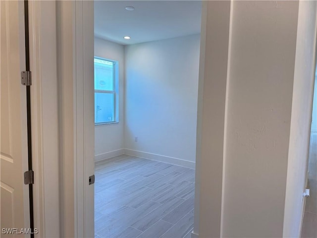 unfurnished room with recessed lighting, baseboards, and wood finished floors