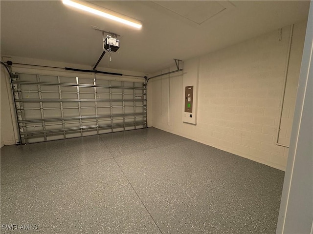 garage with concrete block wall and a garage door opener