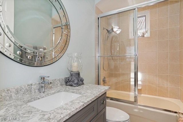 full bathroom with vanity, toilet, and enclosed tub / shower combo