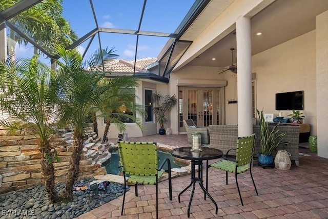 view of patio featuring a lanai, ceiling fan, and french doors