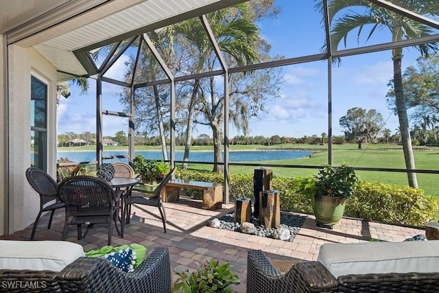 view of patio featuring glass enclosure and a water view