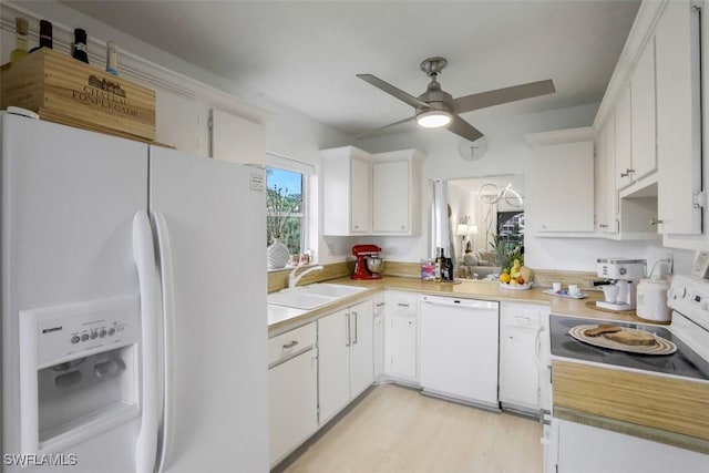 kitchen featuring white appliances, a ceiling fan, a sink, light countertops, and white cabinetry