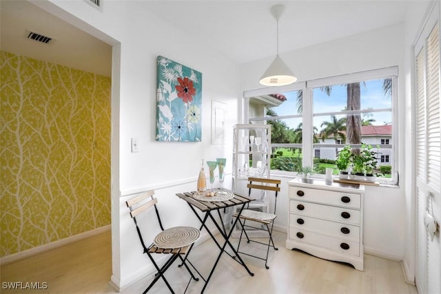 dining area featuring wallpapered walls, baseboards, visible vents, and light wood-type flooring