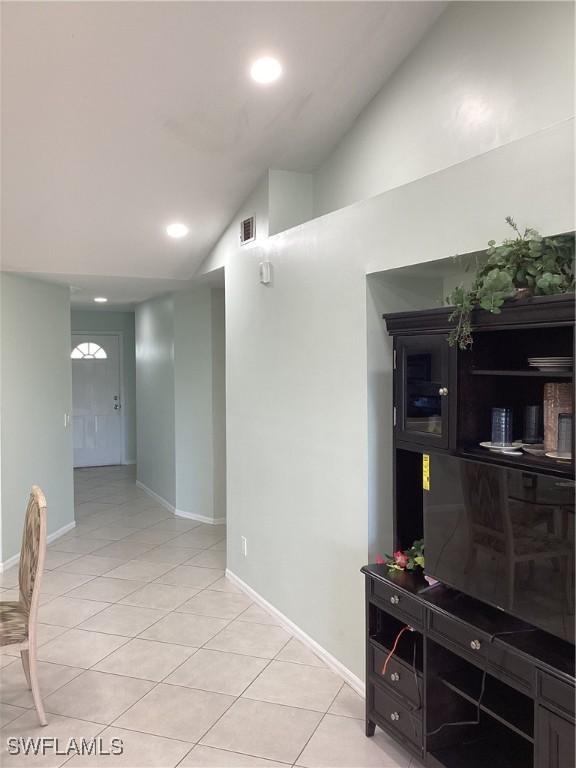 interior space featuring light tile patterned floors and vaulted ceiling