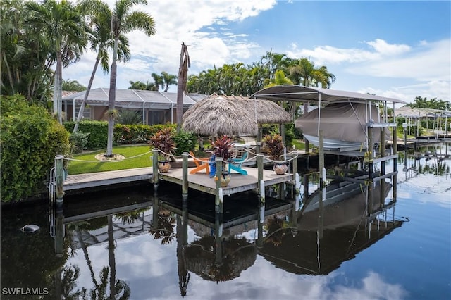 dock area with a yard, a water view, and glass enclosure