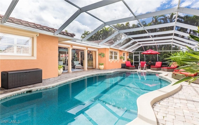 view of pool featuring a patio and glass enclosure