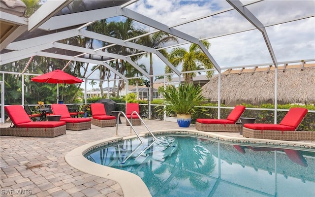 view of swimming pool featuring a patio area and glass enclosure