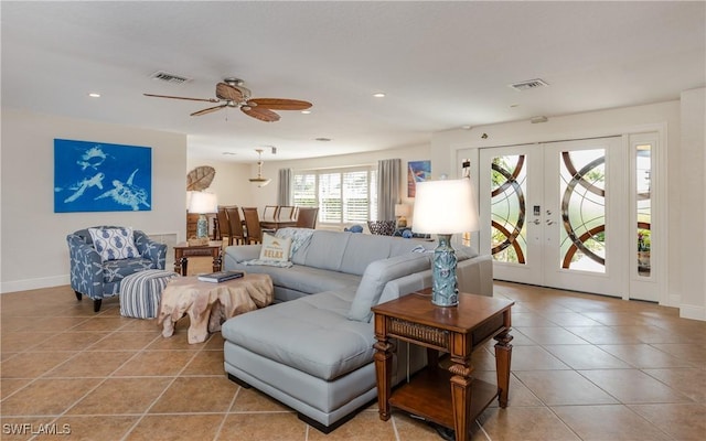 tiled living room with ceiling fan and french doors