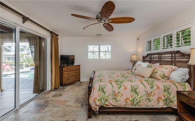 bedroom featuring access to exterior, a textured ceiling, and ceiling fan