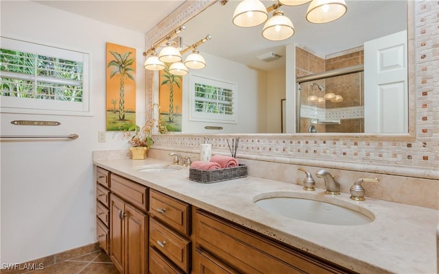 bathroom featuring decorative backsplash, vanity, tile patterned floors, and a shower with shower door