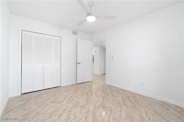 unfurnished bedroom with ceiling fan and a closet