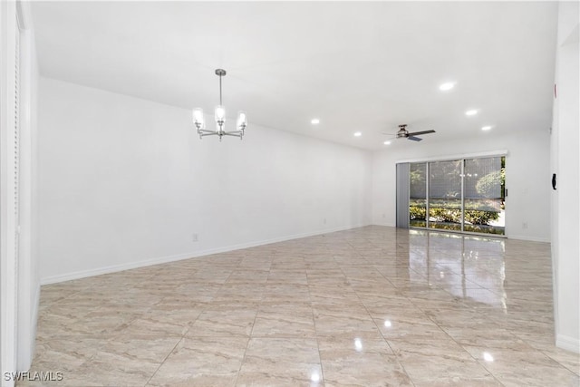 spare room featuring ceiling fan with notable chandelier