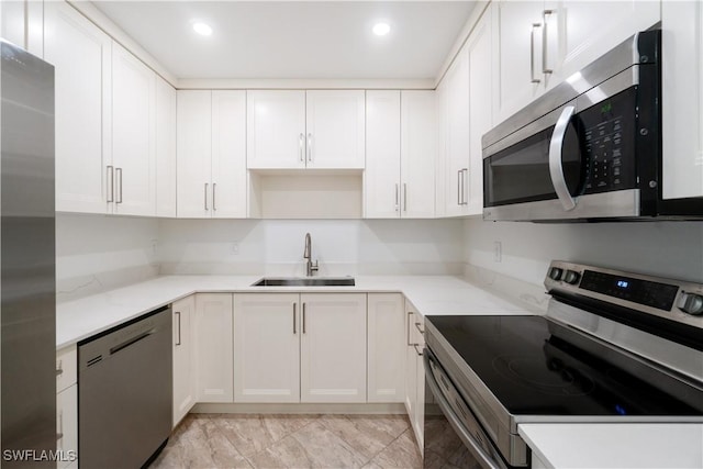 kitchen with sink, white cabinets, and appliances with stainless steel finishes