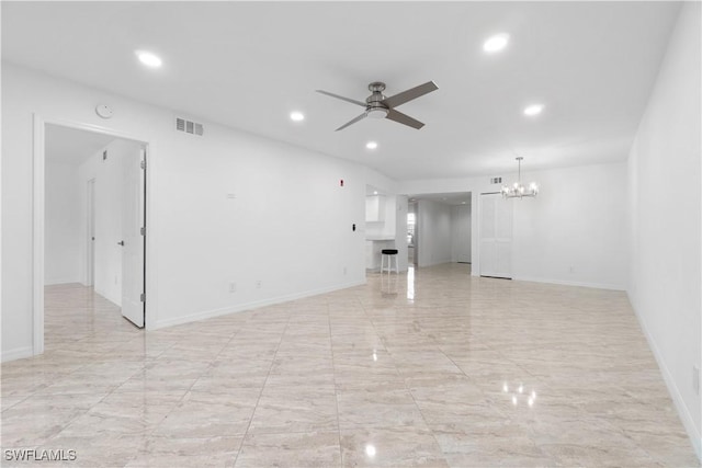 unfurnished room featuring ceiling fan with notable chandelier