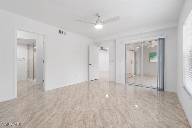 unfurnished bedroom with multiple windows, ceiling fan, and a closet