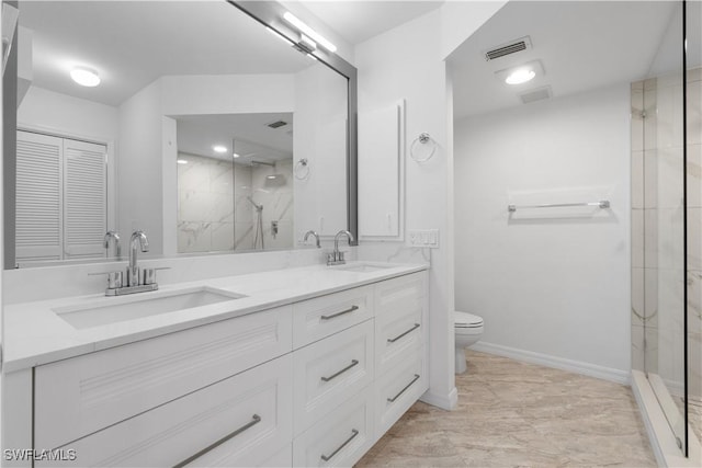 bathroom with vanity, toilet, and a tile shower