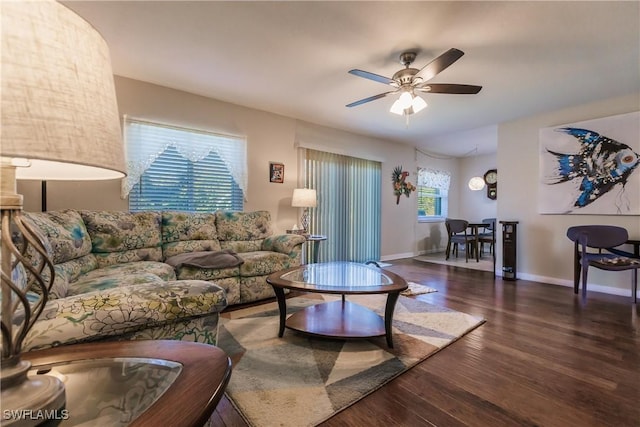 living room with ceiling fan, a healthy amount of sunlight, and dark wood-type flooring