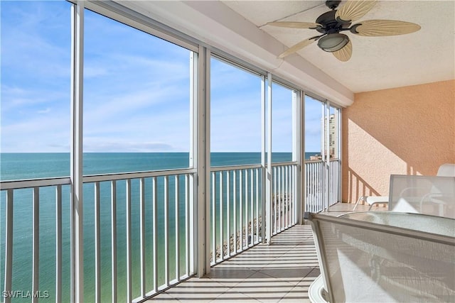 unfurnished sunroom with a water view and ceiling fan