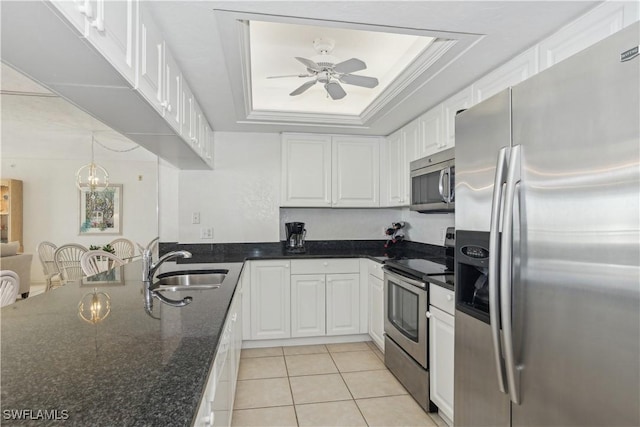 kitchen featuring a raised ceiling, white cabinetry, sink, and stainless steel appliances