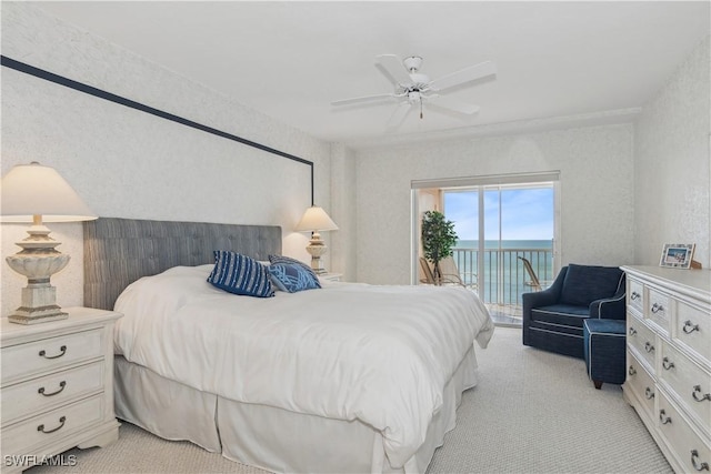 bedroom featuring access to outside, ceiling fan, a water view, and light carpet