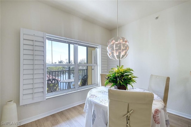 10041 Lake Cove Dr Unit 202, Fort Myers, FL 33908 - dining space featuring a chandelier, wood finished floors, and baseboards